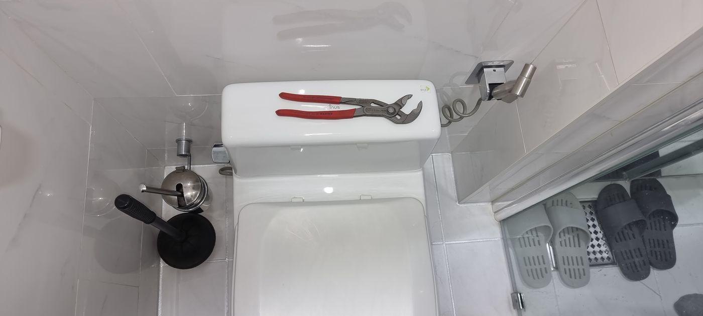 변기 물탱크 위에 올려둔 누수 수리 공구와 펜치
